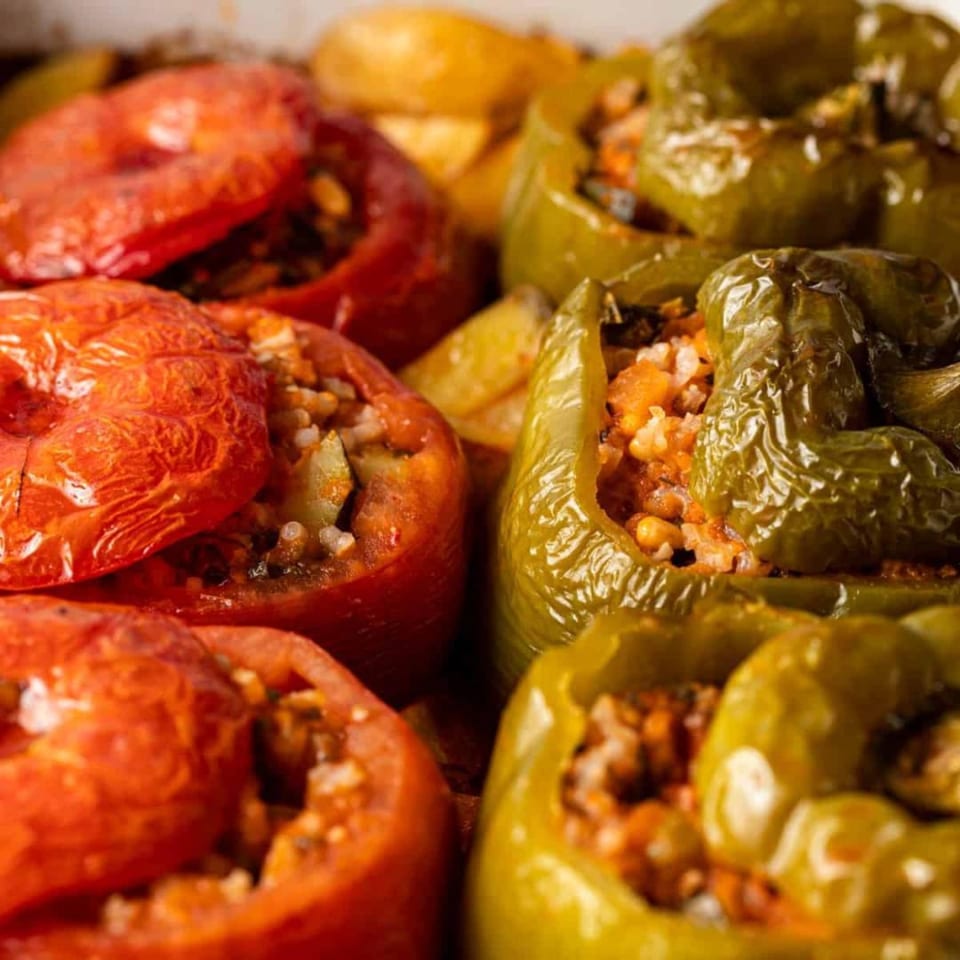 Close-up of Greek yemistes, red tomatoes and green bell peppers stuffed with rice.
