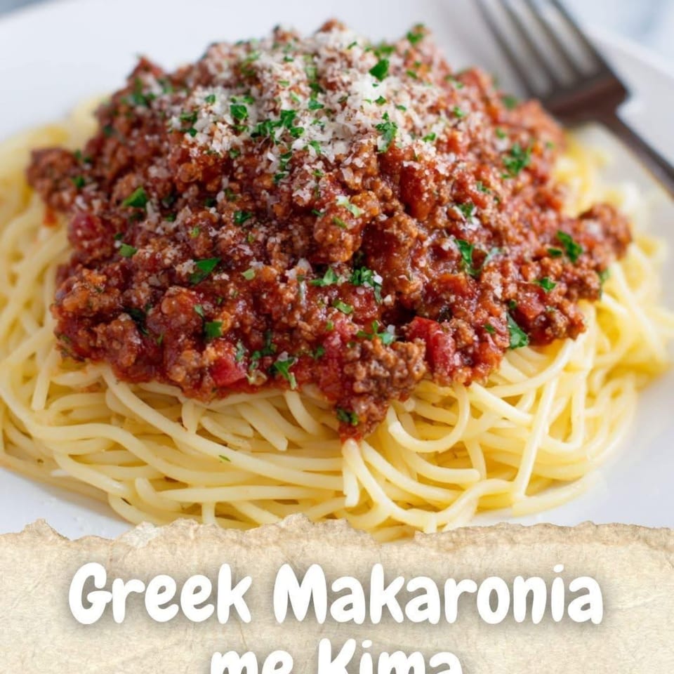 Greek Makaronia me Kima, spaghetti with a rich meat sauce, topped with cheese and parsley.