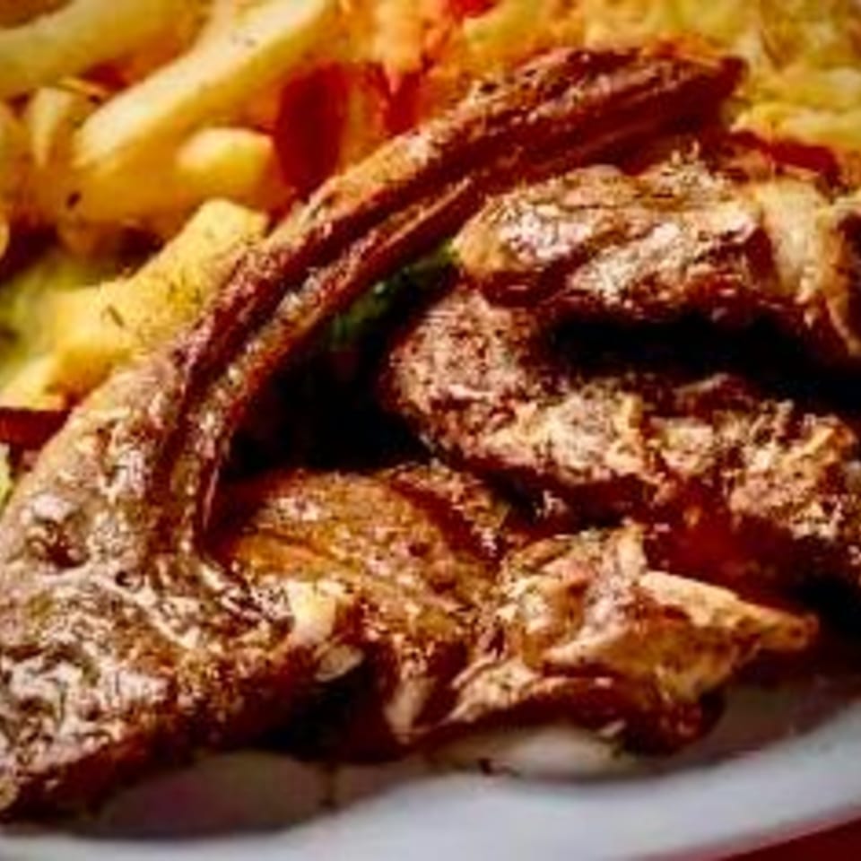 Close-up of grilled lamb chops with french fries and salad, a Greek dish from Gyro House.
